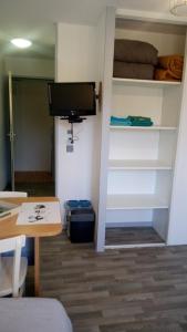 a room with a desk and a tv on a wall at Les Clés Nature Studio 42 in Moutiers-sous-Chantemerle