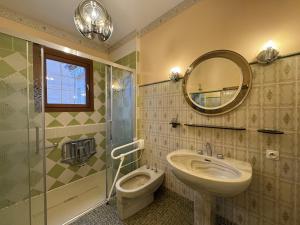 a bathroom with a sink and a toilet and a mirror at La Changéenne - Maison de charme - 12 pers in Changé +24 photos