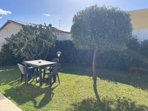 a table and chairs and a tree in a yard at Le Case Al Quadrato Residence in Syracuse