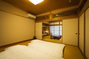 a bedroom with a bed in a room with a window at 囲宿-Kakomiyado- in Eiheiji