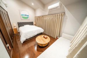 a small room with a bed and a table at 囲宿-Kakomiyado- in Eiheiji