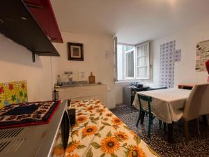 a room with a kitchen with a table and a table and a dining room at Hostello Genovese in Genoa