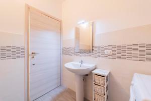 a white bathroom with a sink and a mirror at Monolocale Giulio Cesare in Novara +16 photos