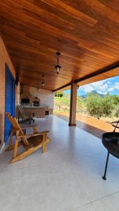 a large covered patio with a wooden ceiling at Chalés Monte das Oliveiras in Domingos Martins