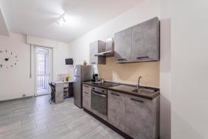 a kitchen with a sink and a refrigerator at Monolocale Giulio Cesare in Novara