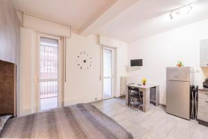 a kitchen with a refrigerator and a table in a room at Monolocale Giulio Cesare in Novara