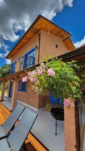 a house with a patio with a table and flowers at Chalés Monte das Oliveiras in Domingos Martins