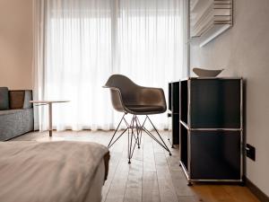 a bedroom with a chair in front of a window at b20 - serviced apartments bern ag in Bern