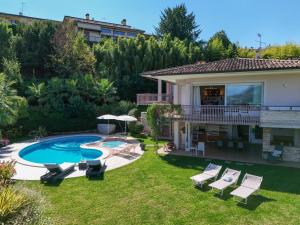 a backyard with a pool and chairs and a house at Villa Caterina in Salò