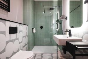 a bathroom with a sink and a toilet and a shower at Focus Hotel Premium Olsztyn in Olsztyn