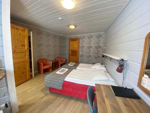 a small bedroom with a bed and a table at Kartano Kievari in Äänekoski