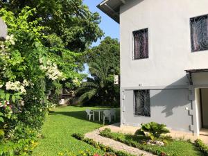 a white house with a yard with a table and chairs at Résidence Danna_ALPHA in Douala