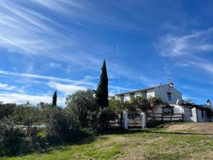 a white house with a fence in a field at Cortijo Majada de las Vacas in Santa Olalla del Cala