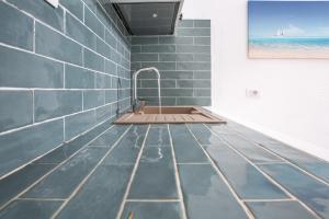 a bathroom with a sink and a blue tiled wall at Ampio Trilocale sul Golfo di Marinella in Santa Marinella +42 photos