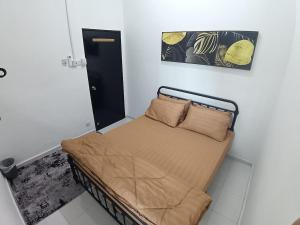 a small bed in a room with at Babah Homestay in Merlimau