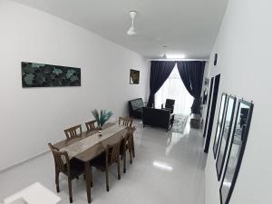 a living room with a wooden table and chairs at Babah Homestay in Merlimau