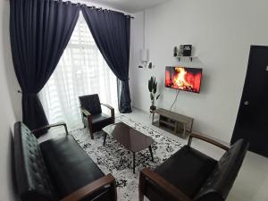 a living room with a couch and chairs and a fireplace at Babah Homestay in Merlimau