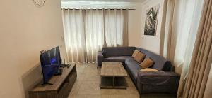 a living room with a couch and a television at Square Resident in Monrovia