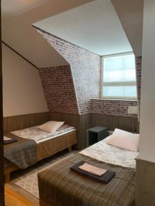 a room with two beds and a brick wall at Kartano Kievari in Äänekoski +54 photos
