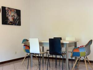 a table with chairs and a painting on the wall at the Lake View apartment in Mendrisio