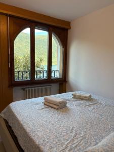 a bedroom with a bed with two towels on it at the Lake View apartment in Mendrisio