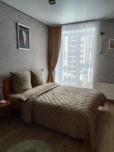 a bedroom with a large bed and a window at Апартаменты у самому Центрі в новому будинку біля ПЛАЗИ - ОЩАДБАНК in Khmelnytskyi