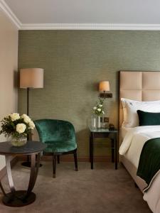 a hotel room with a bed and a green chair at The Rathbone Hotel, Fitzrovia in London +23 photos