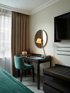 a hotel room with a desk and a mirror at The Rathbone Hotel, Fitzrovia in London