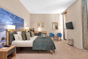 a hotel room with a bed and a desk and chairs at Hotel Beau Rivage in Nice