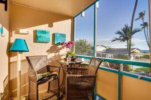 a balcony with a table and chairs and a view of the ocean at Lanai & Community Pool Access: Sunny Central Condo in Kailua-Kona