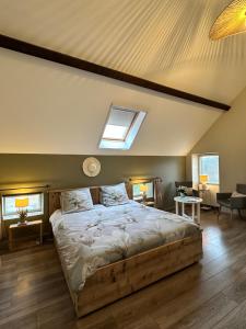 a bedroom with a large bed with a skylight at Chambres d'Hôtes Maison Balady in Bellenaves +30 photos