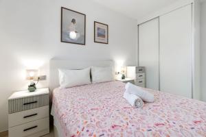 a white bedroom with a bed and a dresser at He Musica in Torrevieja +8 photos