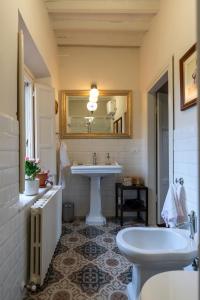 a bathroom with a sink and a toilet and a mirror at La Dimora di Corte in Lucca +37 photos
