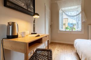 a bedroom with a desk and a bed and a window at La Dimora di Corte in Lucca