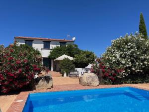 a villa with a swimming pool in front of a house at Cortijo Majada de las Vacas in Santa Olalla del Cala