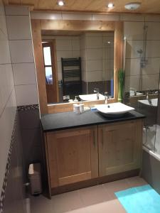 a bathroom with two sinks and a large mirror at Les Saisies Bisanne in Les Saisies