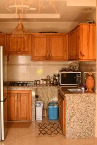 a kitchen with wooden cabinets and a counter top at Adrenalin Surf House in Tamraght Ouzdar +96 photos