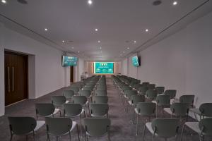 a room with rows of chairs and a screen at Lindos Grand Resort & Spa - Adults Only in Lindos