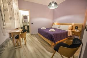 a bedroom with a bed and a desk and chairs at Tzia Lillina B&B in Iglesias