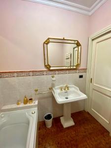 a bathroom with a sink and a tub and a mirror at Rooftop Garden in Bologna