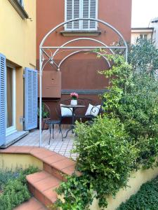 a patio with a table and chairs under an arbor at Rooftop Garden in Bologna