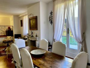 a dining room with a wooden table and white chairs at Rooftop Garden in Bologna +18 photos
