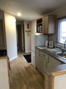 a kitchen with a sink and a refrigerator at Dunes Escape in Lossiemouth