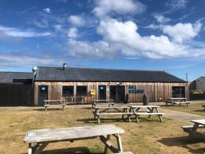 a group of picnic tables in front of a building at Dunes Escape in Lossiemouth