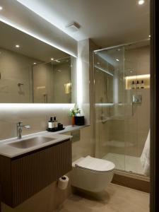 a bathroom with a shower and a toilet and a sink at The Rathbone Hotel, Fitzrovia in London