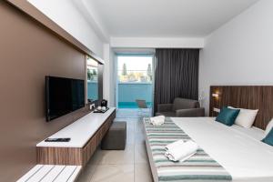 a hotel room with two beds and a flat screen tv at Eleana Hotel in Ayia Napa