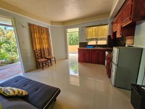 a kitchen with a couch and a refrigerator at Corosol Apartments in Roseau