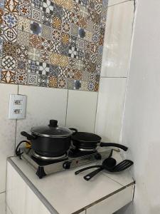 two pots and pans on a stove in a kitchen at Green duplex cottage in Camocim in Camocim