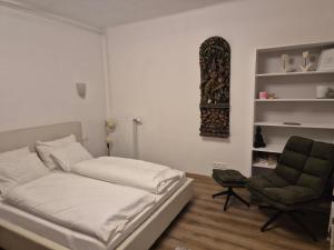 a small bedroom with a bed and a chair at Dein Zuhause am See in Millstatt