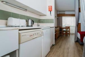 a kitchen with a dishwasher and a sink in a room at Luna Hotel da Oura in Albufeira